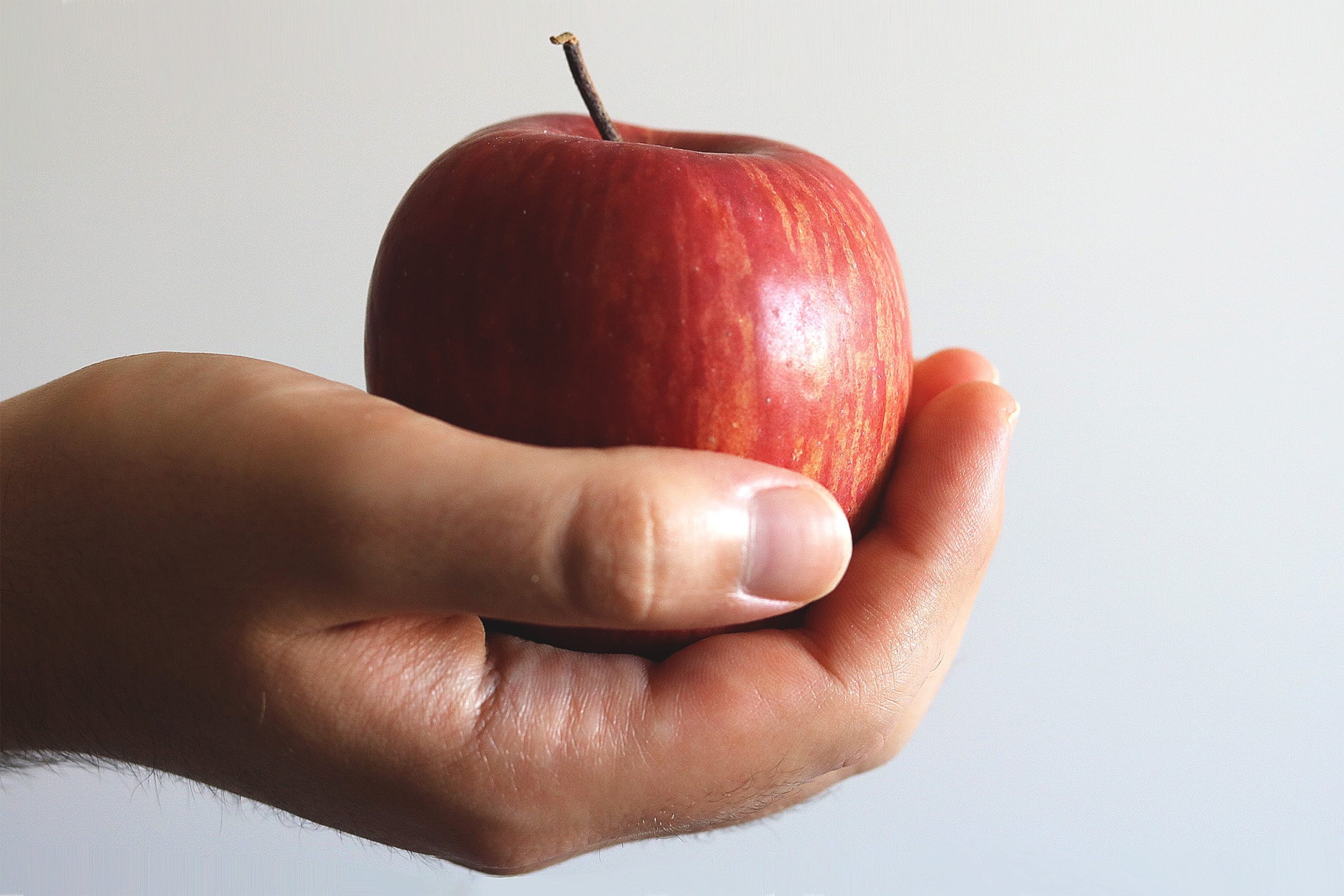 Hand holding a red apple