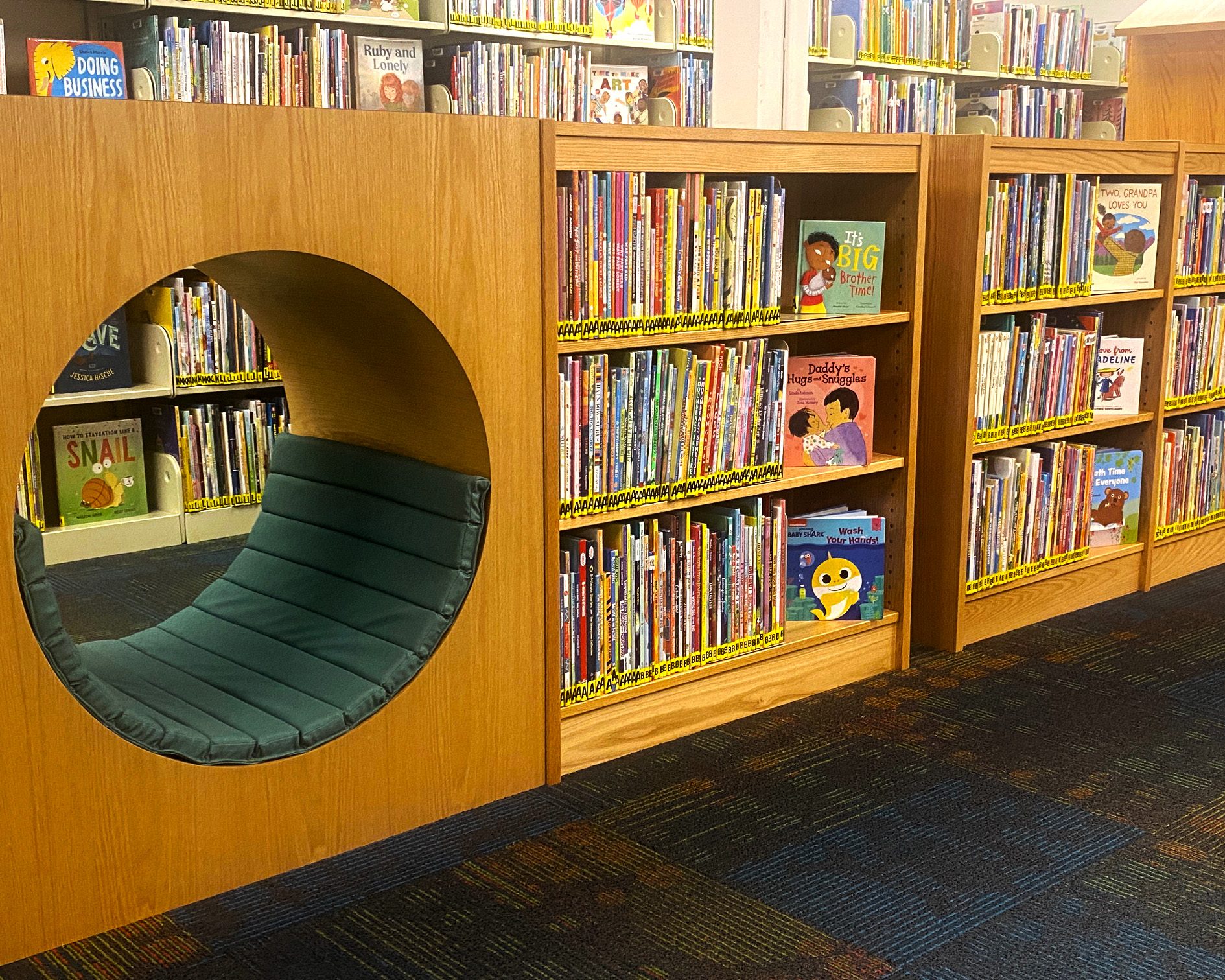 Library shelves with children's books and a circular reading nook.