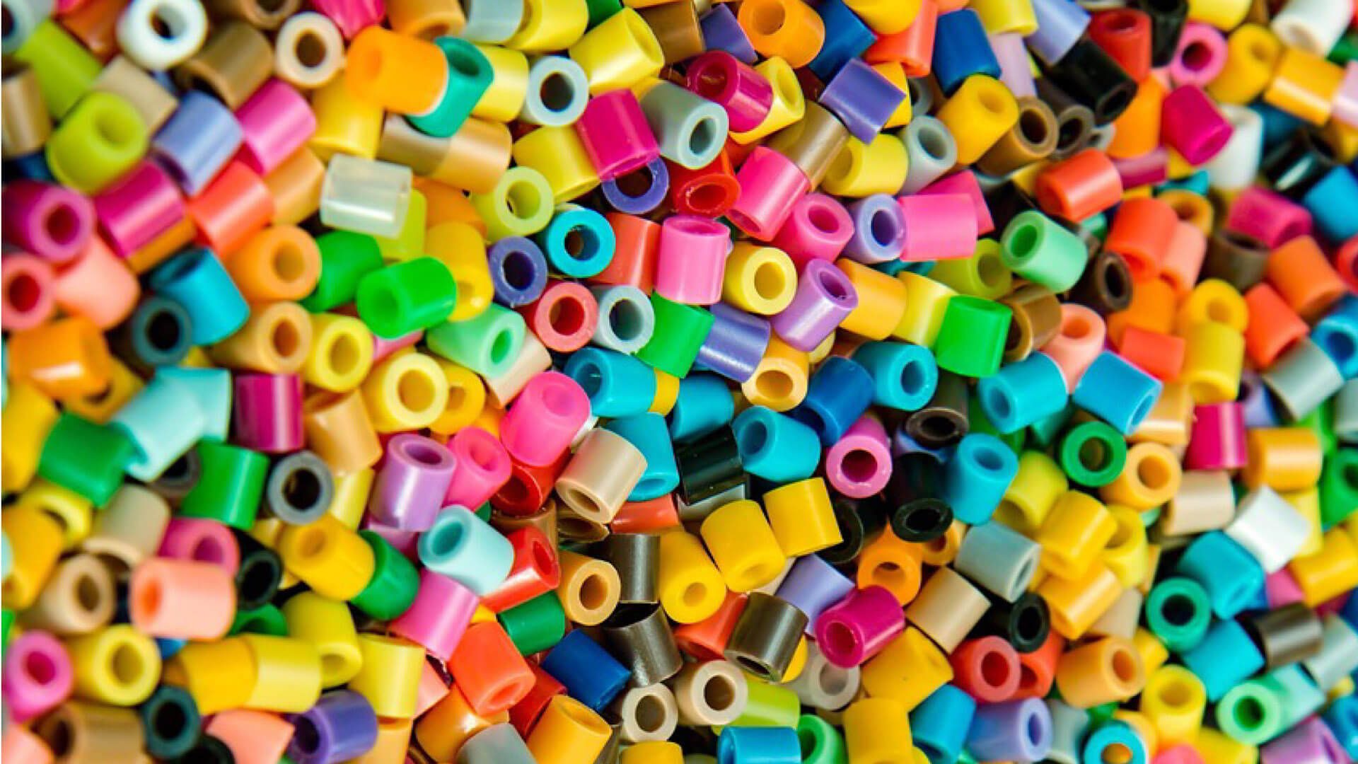 A close-up of colorful plastic fuse beads.