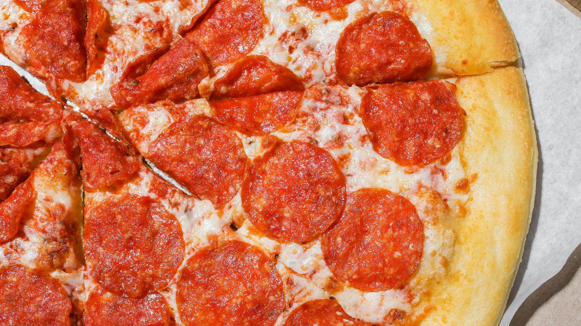 Overhead shot of a hot, cheesy pepperoni pizza with a thick crust.