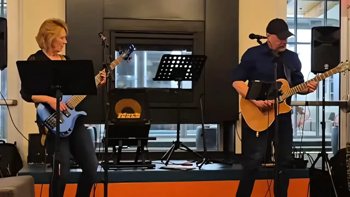 A live photo of the Victor Samalot Duo on stage, playing base guitar and acoustic guitar respectively.