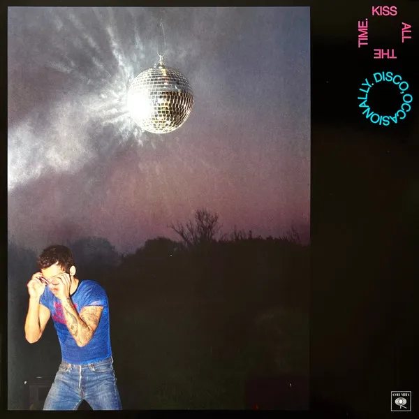 Album cover. A man in a blue shirt standing under a large disco ball at dusk, adjacent to a black panel with stylized text.