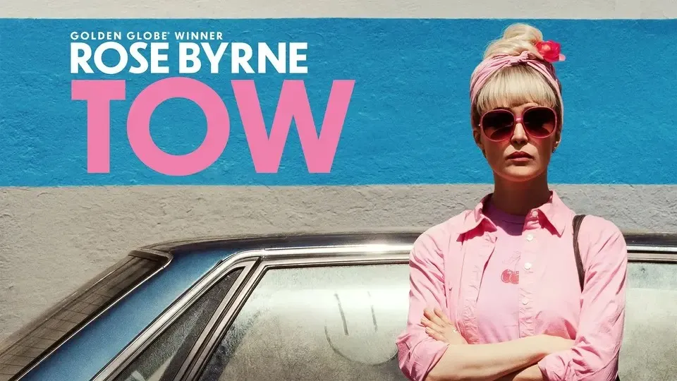Golden Globe Winner Rose Byrne, serious in pink retro outfit & sunglasses. 'TOW' movie poster.